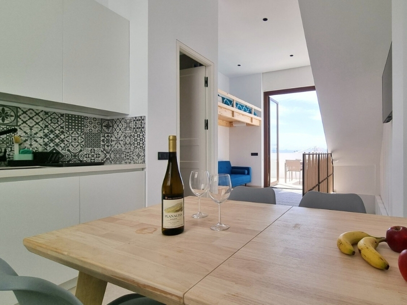 Cocina y sala de estar abiertas a una terraza con vista al mar.
