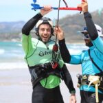 Un kitesurfista practicando kitesurf en Tarifa en otoño, durante una soleada tarde de septiembre, con la playa de Los Lances al fondo.