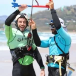Un kitesurfista practicando kitesurf en Tarifa en otoño, durante una soleada tarde de septiembre, con la playa de Los Lances al fondo.